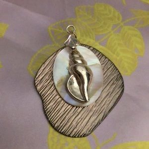 This a gold tone pendant sea shell necklace.